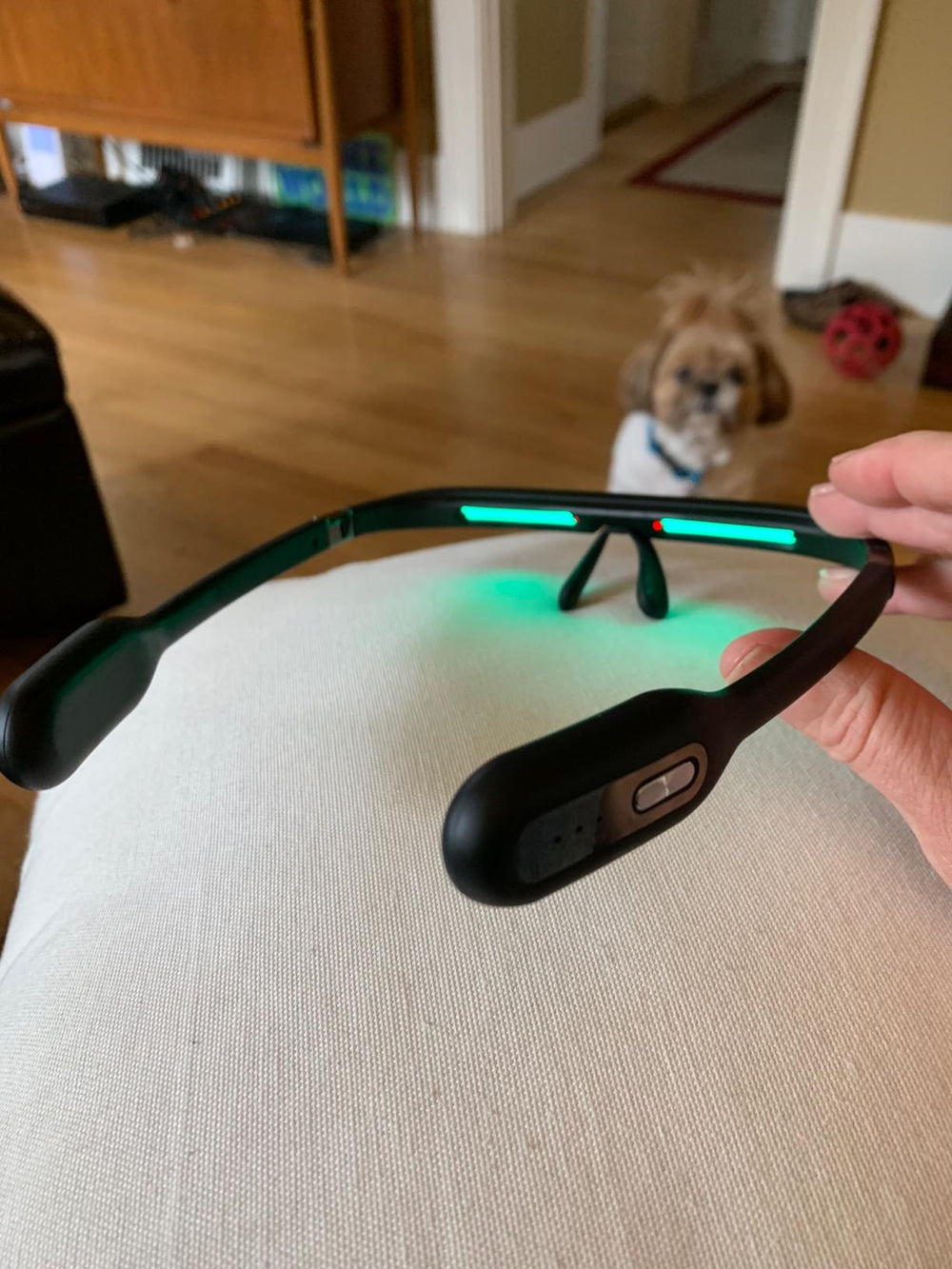 Close-up of black LUNO Vision smart glasses with glowing green light — focus on technology and detail.